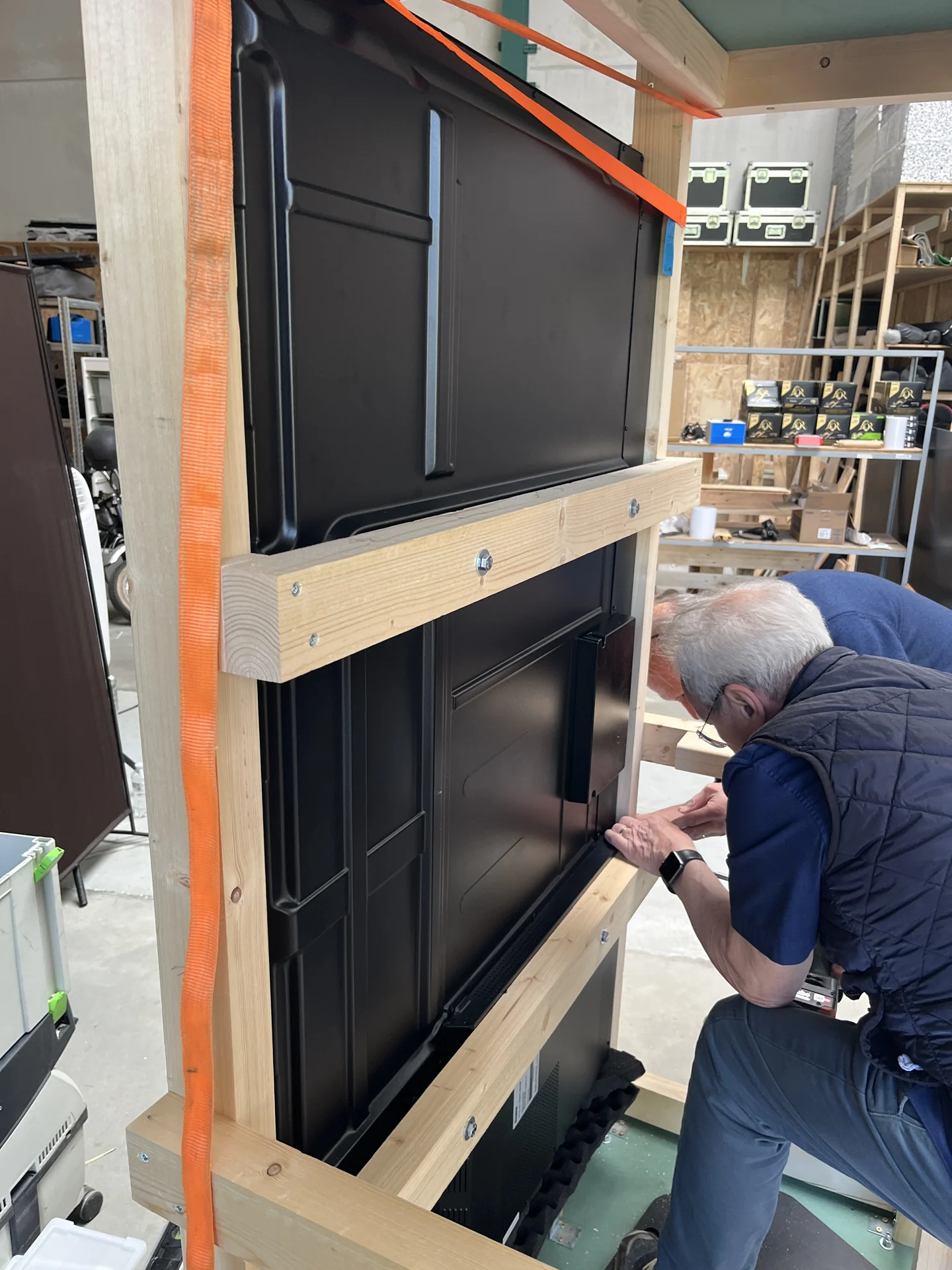 Het grote scherm wordt in de houten behuizing van de Telenet AR booth gemonteerd